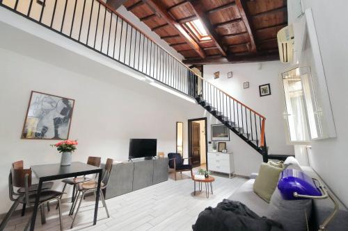 een woonkamer met een bank, een tafel en een trap bij Fidelio Holiday Home in Rome
