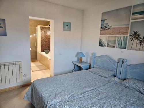 1 Schlafzimmer mit einem blauen Bett und einem Badezimmer in der Unterkunft Casa Las Patas De Los Patos in La Sabinita