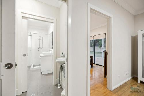 a white bathroom with a sink and a mirror at Dune View in Lancelin