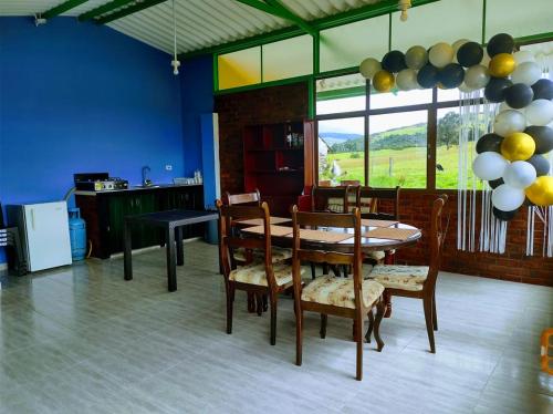 a dining room with a table and chairs and balloons at Casa de Campo San Cayetano de los vientos in Tibasosa