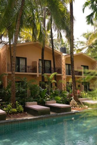 a resort with a swimming pool and palm trees at ALTR NATIV Morjim, Goa in Morjim