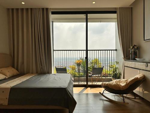 a bedroom with a bed and a chair and a balcony at Swanlake ecopark Hanoi-Calm homestay in Kim Quan
