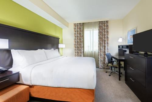 a hotel room with a large bed and a desk at Staybridge Suites - Miami International Airport by IHG in Miami