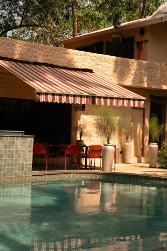 a swimming pool with a tent and a table and chairs at ALTR NATIV Morjim, Goa in Morjim