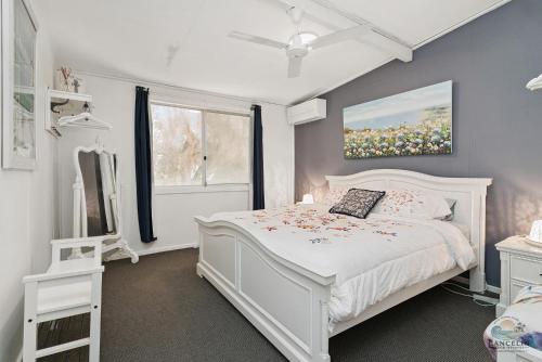 ein weißes Schlafzimmer mit einem weißen Bett und einem Fenster in der Unterkunft Hamptons in Lancelin