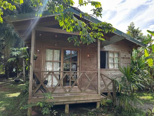 een klein houten huisje met een veranda bij Bobinsana INN in Puerto Limón