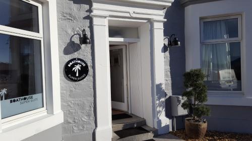a front door of a house with a sign on it at Boat House Super Suites in Rothesay