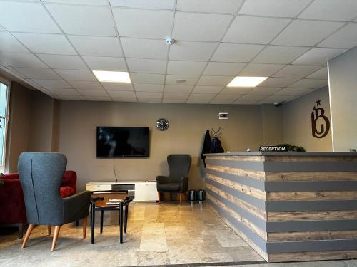 a waiting room with two chairs and a tv at Big Inn Luxury Hotel in Biga