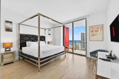 a bedroom with a canopy bed with a view of the ocean at Spacious VIP Penthouse with Ocean & Intracoastal Views, Private Entry, Resort Amenities in Hallandale Beach