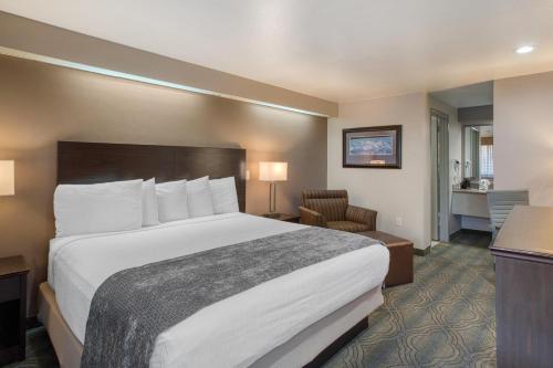 a hotel room with a large bed and a chair at SureStay by Best Western Salt Lake City Downtown in Salt Lake City