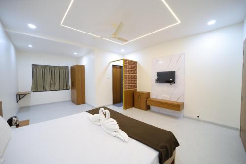 een kamer met 2 bedden en een tv. bij Shivjanmabhumi Resort in Junnar