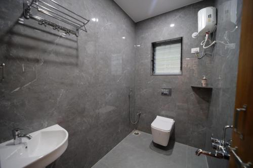 een badkamer met toilet en wastafel bij Shivjanmabhumi Resort in Junnar