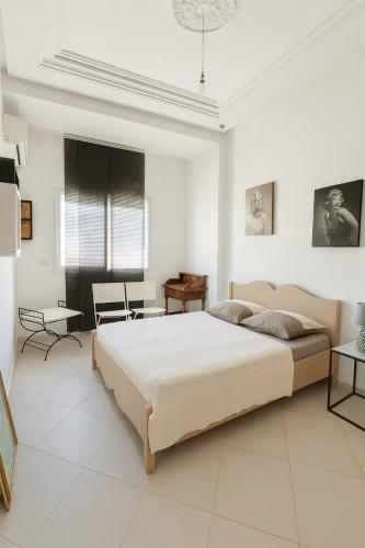 ein weißes Schlafzimmer mit einem großen Bett und einem Tisch in der Unterkunft Apartment Rue Kifa Meknes in Meknès