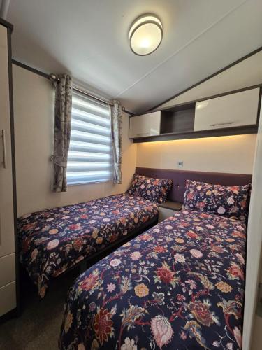 ein kleines Schlafzimmer mit zwei Betten und einem Fenster in der Unterkunft Rody's Cosy Corner in Crowle
