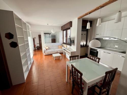eine Küche und ein Wohnzimmer mit Tisch und Stühlen in der Unterkunft Luminoso appartamento in pieno centro città NUOVO! in Belluno