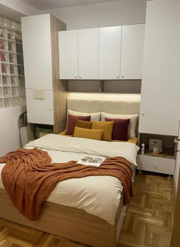 a bedroom with a large bed with white cabinets at Ahmet Pasha apartments ne qender te Pejes me nji dhom te fjetjes e sallon qe i ka dy shtreter in Peje
