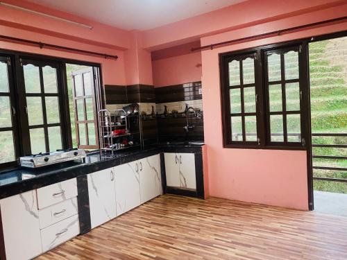 Una cocina con paredes rosas y encimeras negras. en Bhaktapur Yog Homestay, en Bhaktapur