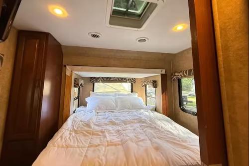 Prairie Junction Resort - Furnished RV Apartments في Stettler: سرير كبير في منتصف عربة سكنية