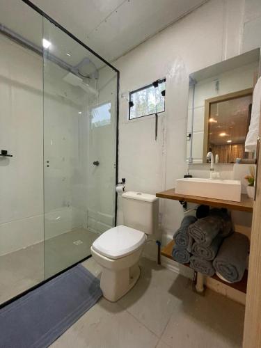 a bathroom with a toilet and a shower and a sink at Estudio Praia do Estaleiro - Balneário Camboriú in Balneário Camboriú