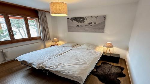 a bedroom with a large bed with two lamps at Superbe appartement avec 2 chambres avec vue imprenable sur les Alpes in Crans-Montana