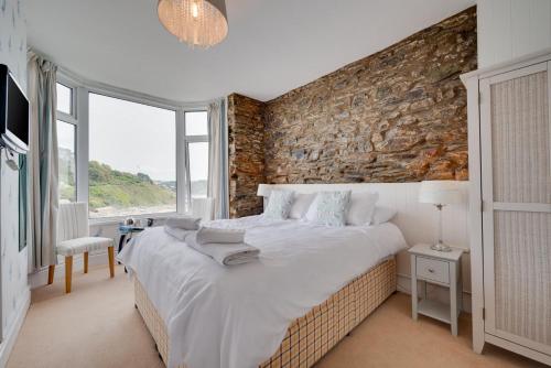 Un dormitorio con una cama grande y una pared de ladrillo. en 4 Bed in Looe oc-l30051, en Looe