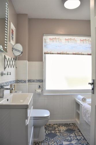 a bathroom with a toilet and a sink and a window at 2 Bed in Looe oc-l10082 in Looe