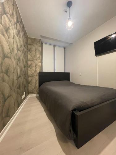 a bedroom with a bed and a stone wall at Studio centre-ville in Besançon