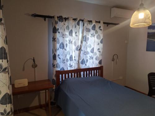 a bedroom with a blue bed and a window at 1 Bedroom Apartment on ground floor with access to swimming pool in Rose Hill