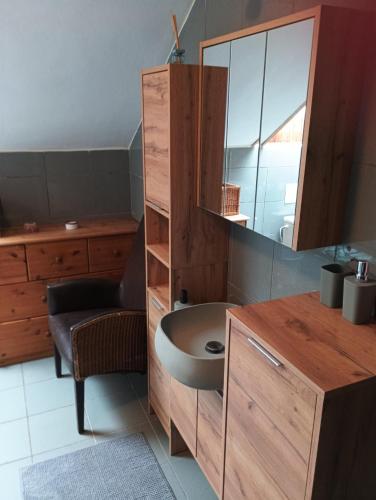 Un baño con lavabo y mueble con espejo. en Chalet Sedmihori, en Staré Sedlo