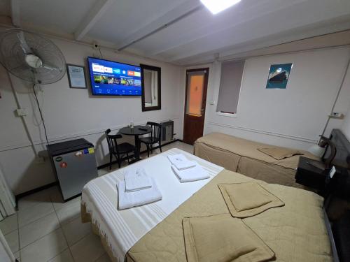 Una habitación de hotel con dos camas y un televisor de pantalla plana. en Marina Bella Habitación 2, en Rada Tilly