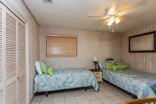 ein Schlafzimmer mit zwei Betten und einem Deckenventilator in der Unterkunft 510 A Magnolia in Ebo Landing
