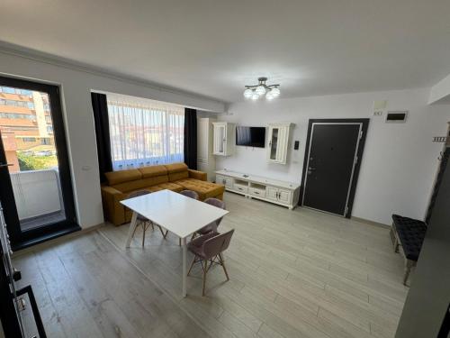 een woonkamer met een tafel en een bank bij Sarah Apartment in Constanţa