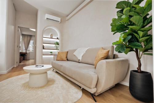 un soggiorno con divano e pianta in vaso di Central Designer Condo a Bucarest