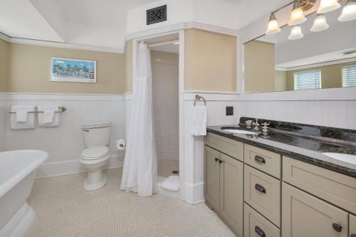 a bathroom with a toilet and a sink and a mirror at Shiphouse 3 - Third Floor in Saint Simons