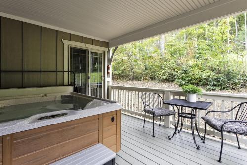 a porch with a tub and a table and chairs at The Maple Cottage in Asheville
