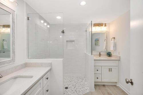 a white bathroom with a tub and a sink at 8 Stewart Lane in Jekyll Island