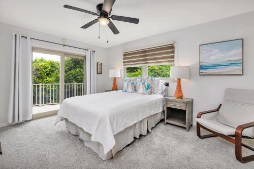 a white bedroom with a bed and a window at 8 Stewart Lane in Jekyll Island