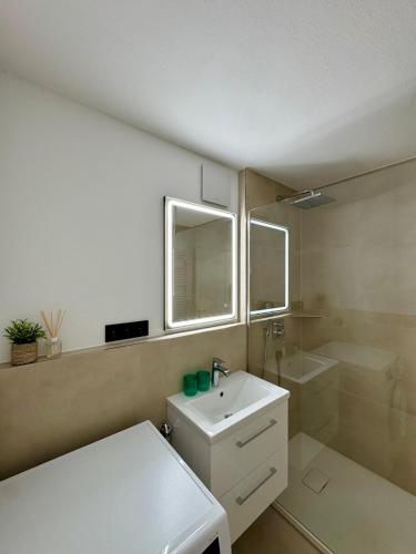 een badkamer met een witte wastafel en een spiegel bij Ferienwohnung No 5`2 Rottweil in Rottweil