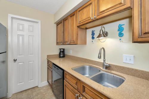 eine Küche mit Holzschränken und einer Spüle in der Unterkunft Island Retreat #2513-2 in Island Retreat