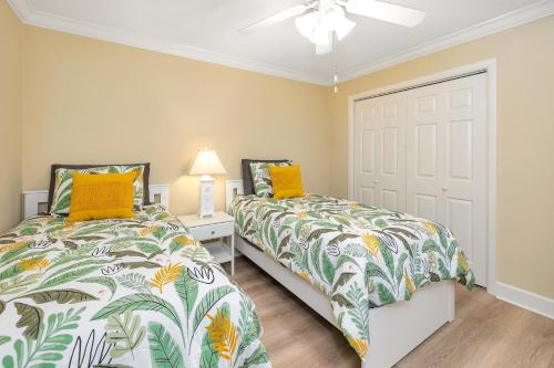 ein Schlafzimmer mit zwei Betten und einem Deckenventilator in der Unterkunft Island Retreat #2513-2 in Island Retreat