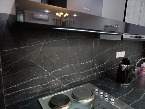 eine Küche mit einer Arbeitsplatte aus schwarzem Marmor in der Unterkunft Apartment NEW in Taschkent