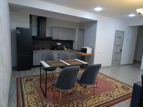 eine Küche mit einem Tisch und 2 Stühlen auf einem Teppich in der Unterkunft Apartment NEW in Taschkent