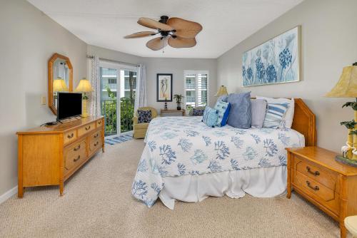 a bedroom with a bed and a ceiling fan at Beach Club #107 in Saint Simons Island