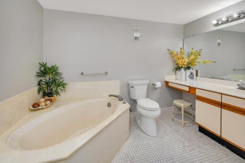 a bathroom with a tub and a toilet and a sink at Beach Club #107 in Saint Simons Island