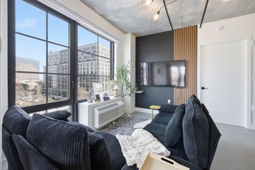 ein Wohnzimmer mit Couch und großem Fenster in der Unterkunft Modern Luxe 2BR Escape, City Views, 1 stop to NYC in Newark