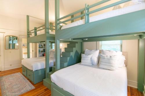 a bedroom with two bunk beds with white sheets at 37 Coast - Ebb Tide Cottage in East End