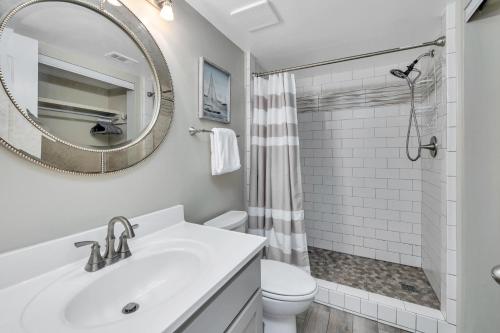 a white bathroom with a sink and a mirror at Shipwatch #106 in East End