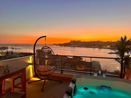 a balcony with a tub and a view of the ocean at Trihouse Douro and Sea View in Vila Nova de Gaia