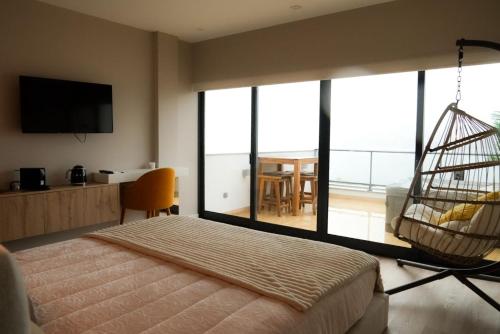 a bedroom with a swinging bed and a balcony at Trihouse Douro and Sea View in Vila Nova de Gaia