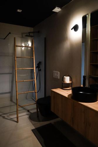 a bathroom with a black sink and a ladder at Trihouse Douro and Sea View - jacuzzi only in Room 4 - Jacuzzi apenas no quarto 4 in Vila Nova de Gaia